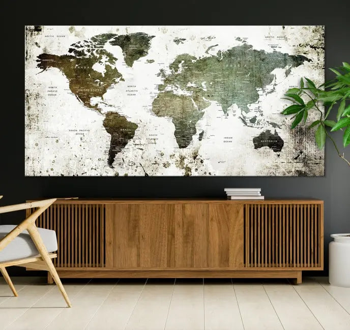 A Wall Art Push Pin World Map Canvas Print is displayed, showcasing an abstract world map in earthy tones. This museum-quality canvas is ready to hang and includes a UV-protective coating to maintain its vibrant shades.