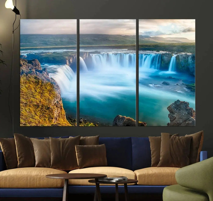 A large triptych of the "Wall Art Waterfall Canvas Print Grand Waterfall on a Plain" adorns the living room wall, crafted on museum-quality canvas. This artwork—handmade in the USA—comes with free shipping for those wishing to elevate their space.