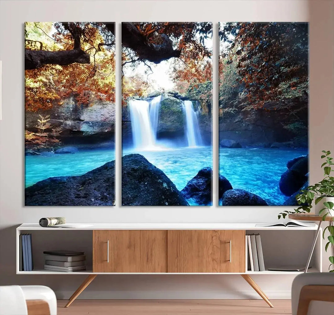 In the living room, a hand-assembled triptych titled "Wall Art Waterfall Canvas Print Great Double Waterfalls with Bright Water in Forest" is displayed on museum-quality canvas.