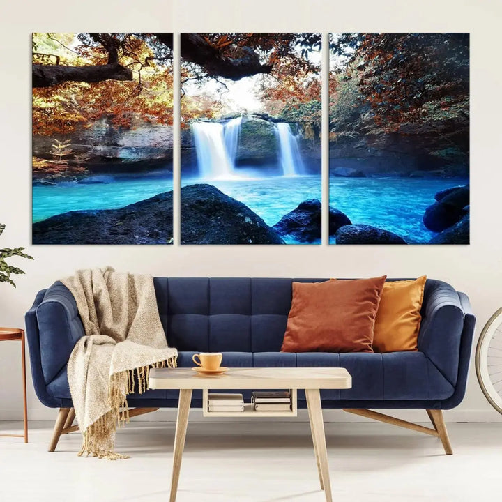 In the living room, a hand-assembled triptych titled "Wall Art Waterfall Canvas Print Great Double Waterfalls with Bright Water in Forest" is displayed on museum-quality canvas.