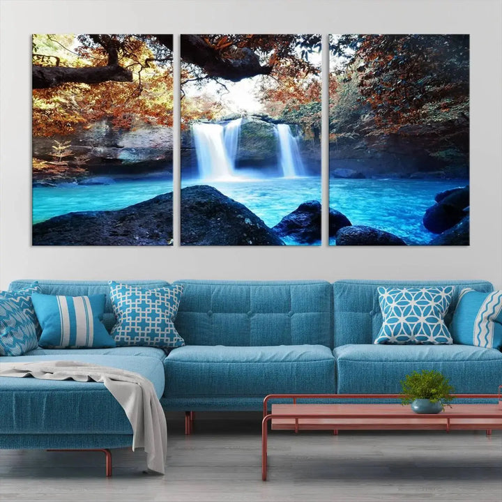 In the living room, a hand-assembled triptych titled "Wall Art Waterfall Canvas Print Great Double Waterfalls with Bright Water in Forest" is displayed on museum-quality canvas.