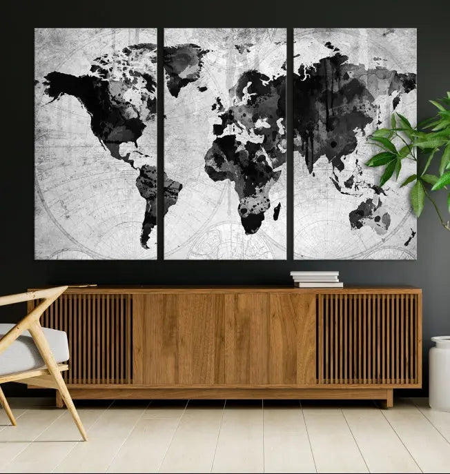 The wall is adorned with a striking three-panel piece from the "Wall Art World Map Canvas Print" collection. Crafted by a professional artisan on museum-quality canvases, this world map art's vibrance is preserved with UV-protective coating, beautifully enhanced against the dark backdrop.