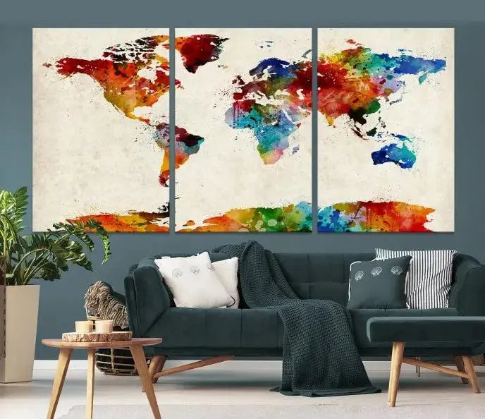 The Wall Art World Map Watercolor Canvas Print, featuring museum-quality craftsmanship, adorns the wall in a chic living room. This triptych includes a hand-assembled frame that enhances its elegance and adds an artistic touch to the setting.