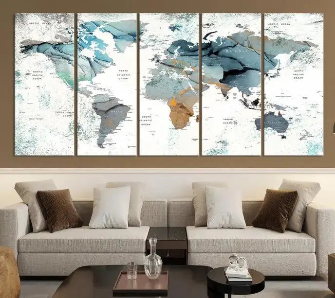 The Watercolor Push Pin World Map Wall Art, a world map painting on museum-quality canvas in blue and gray hues with a UV-protective coating, hangs prominently in the room.