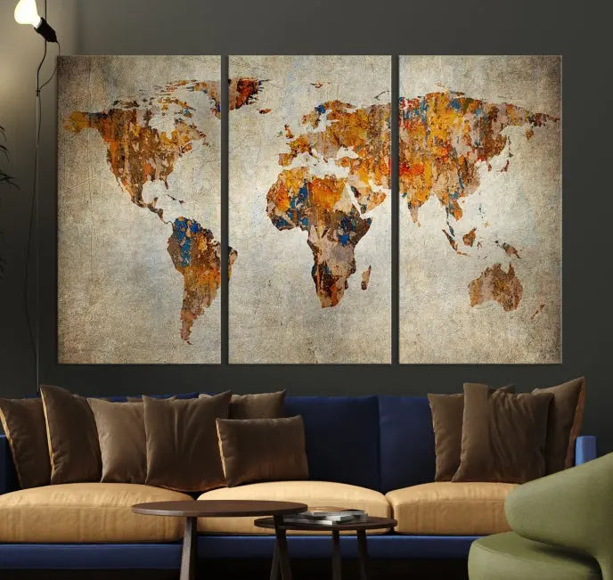 A triptych of Watercolor World Map Canvas Wall Art Prints is displayed in a dimly lit room.