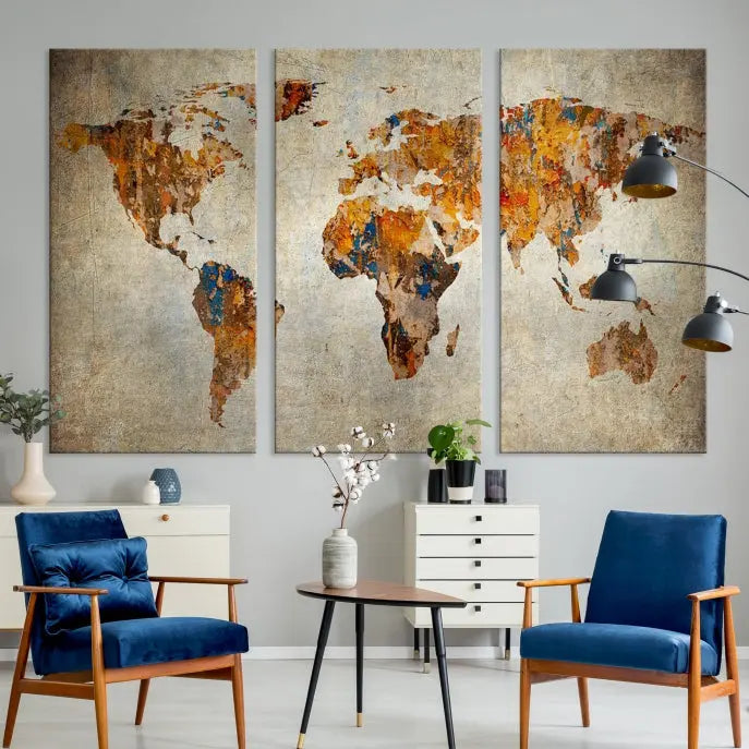 A triptych of Watercolor World Map Canvas Wall Art Prints is displayed in a dimly lit room.