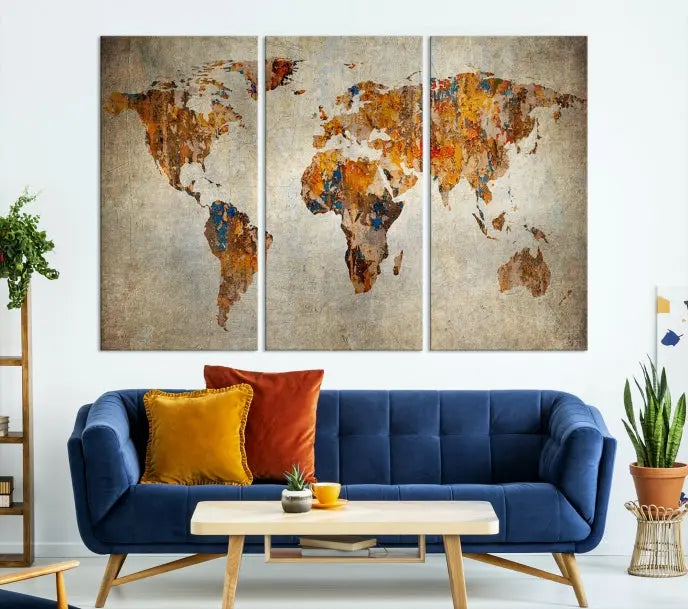 A triptych of Watercolor World Map Canvas Wall Art Prints is displayed in a dimly lit room.