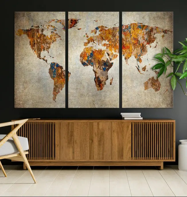 A triptych of Watercolor World Map Canvas Wall Art Prints is displayed in a dimly lit room.