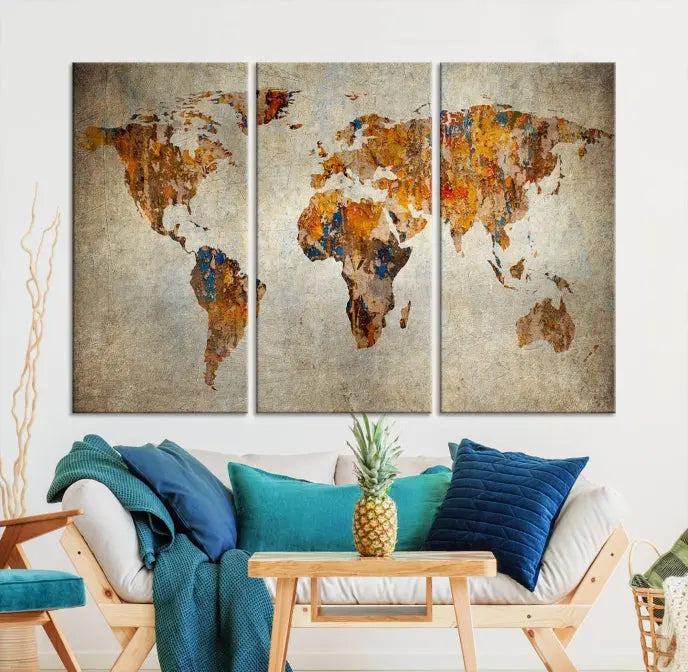 A triptych of Watercolor World Map Canvas Wall Art Prints is displayed in a dimly lit room.