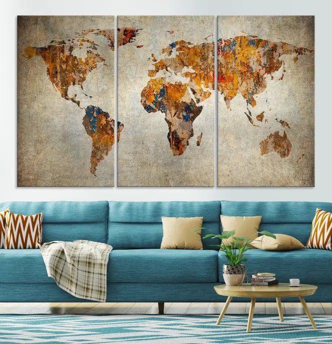 A triptych of Watercolor World Map Canvas Wall Art Prints is displayed in a dimly lit room.