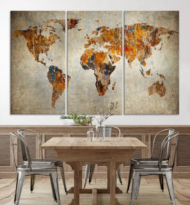 A triptych of Watercolor World Map Canvas Wall Art Prints is displayed in a dimly lit room.