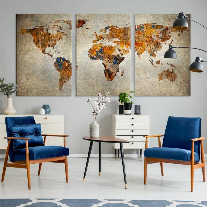 A triptych of Watercolor World Map Canvas Wall Art Prints is displayed in a dimly lit room.