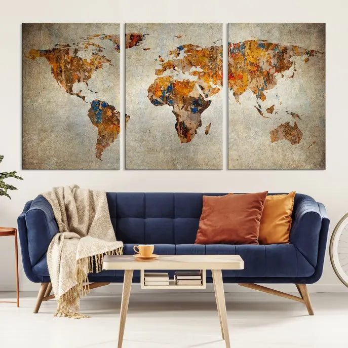 A triptych of Watercolor World Map Canvas Wall Art Prints is displayed in a dimly lit room.