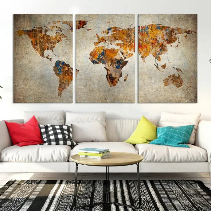 A triptych of Watercolor World Map Canvas Wall Art Prints is displayed in a dimly lit room.