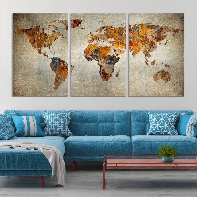 A triptych of Watercolor World Map Canvas Wall Art Prints is displayed in a dimly lit room.