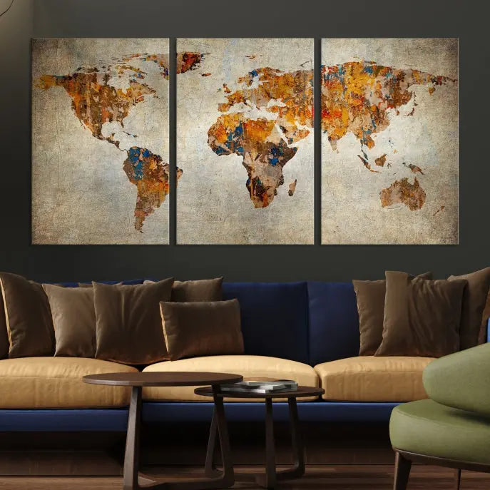 A triptych of Watercolor World Map Canvas Wall Art Prints is displayed in a dimly lit room.