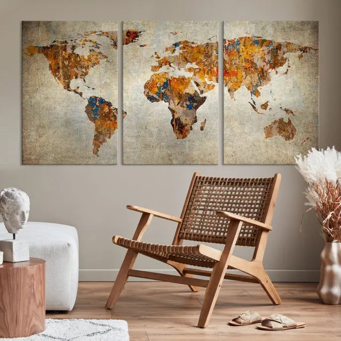 A triptych of Watercolor World Map Canvas Wall Art Prints is displayed in a dimly lit room.