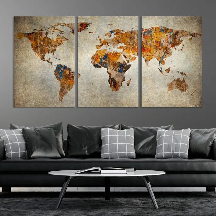 A triptych of Watercolor World Map Canvas Wall Art Prints is displayed in a dimly lit room.