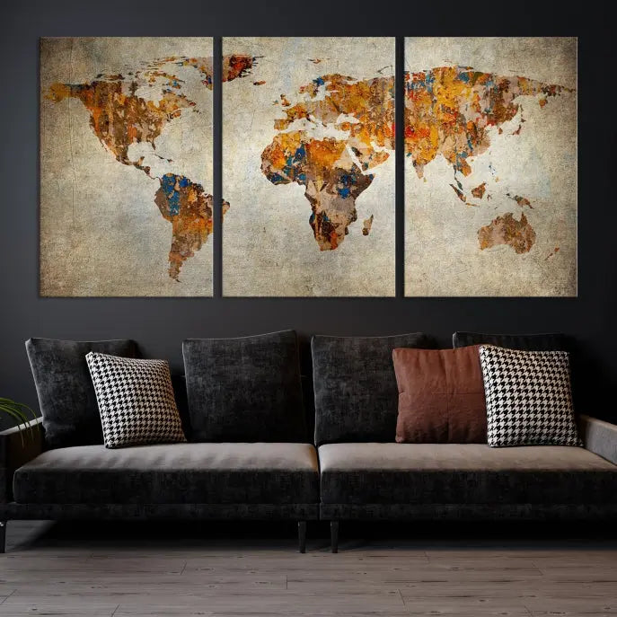 A triptych of Watercolor World Map Canvas Wall Art Prints is displayed in a dimly lit room.