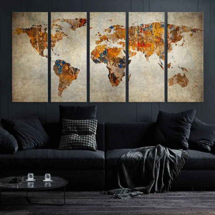 A triptych of Watercolor World Map Canvas Wall Art Prints is displayed in a dimly lit room.