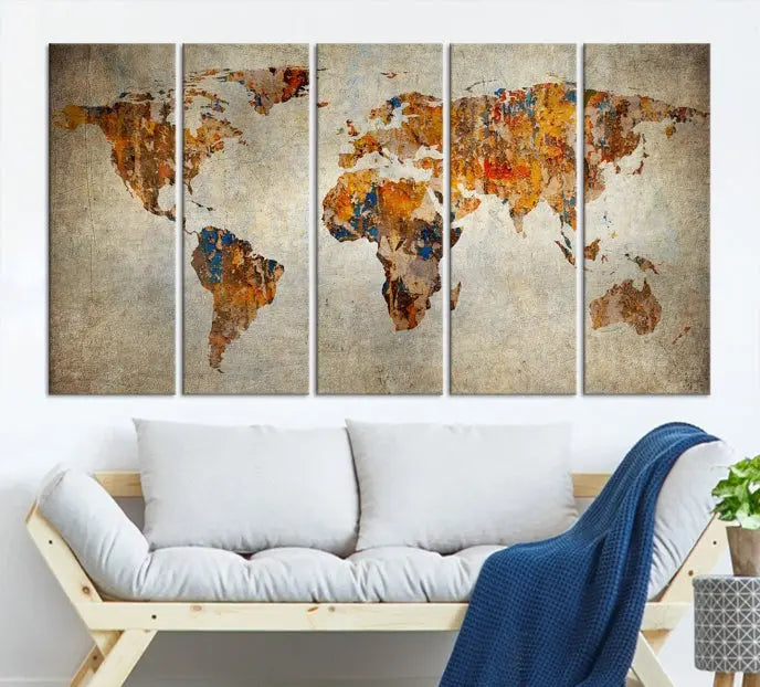 A triptych of Watercolor World Map Canvas Wall Art Prints is displayed in a dimly lit room.