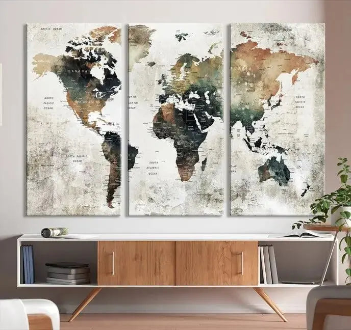 The dark wall is elegantly adorned with the Watercolor World Map Wall Art Canvas Print in a triptych style. Each canvas features a UV-protective coating and is ready to hang, seamlessly blending sophistication with practicality.