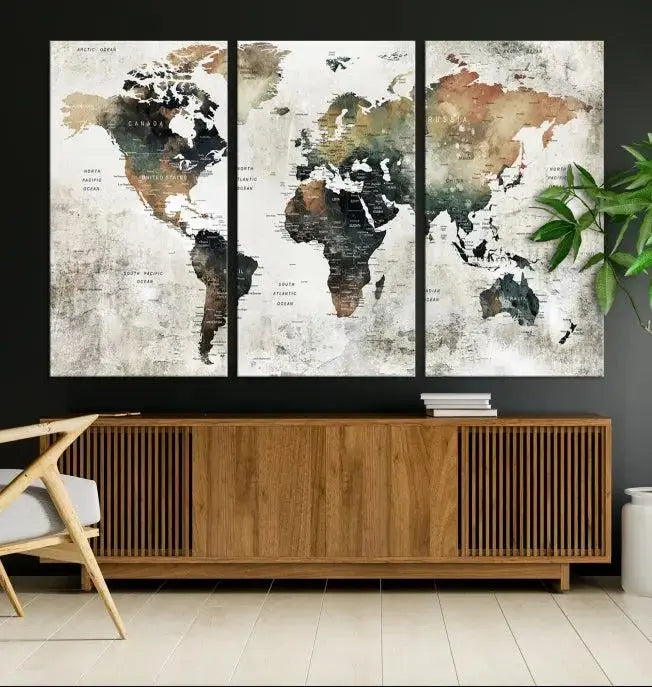 The dark wall is elegantly adorned with the Watercolor World Map Wall Art Canvas Print in a triptych style. Each canvas features a UV-protective coating and is ready to hang, seamlessly blending sophistication with practicality.