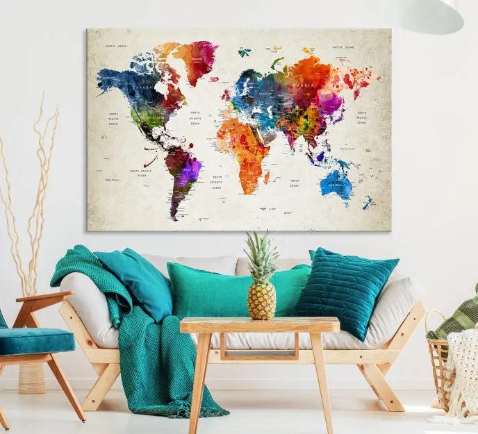 A Watercolor World Map Wall Art Canvas Print, spread across three panels, adorns a dark wall.