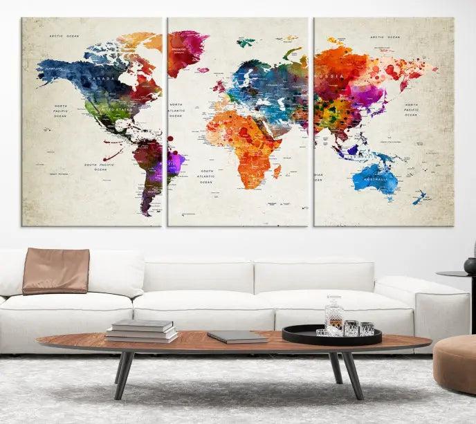 A Watercolor World Map Wall Art Canvas Print, spread across three panels, adorns a dark wall.