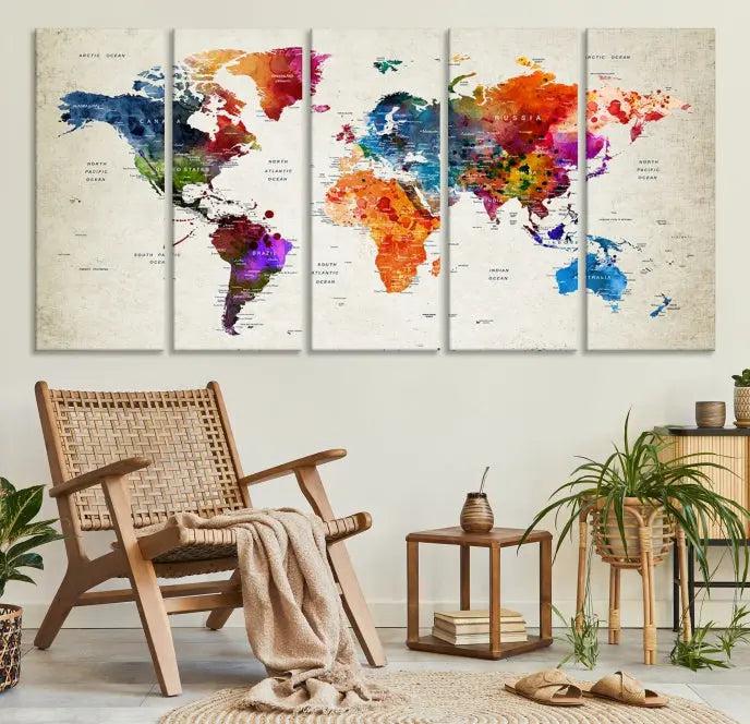 A Watercolor World Map Wall Art Canvas Print, spread across three panels, adorns a dark wall.