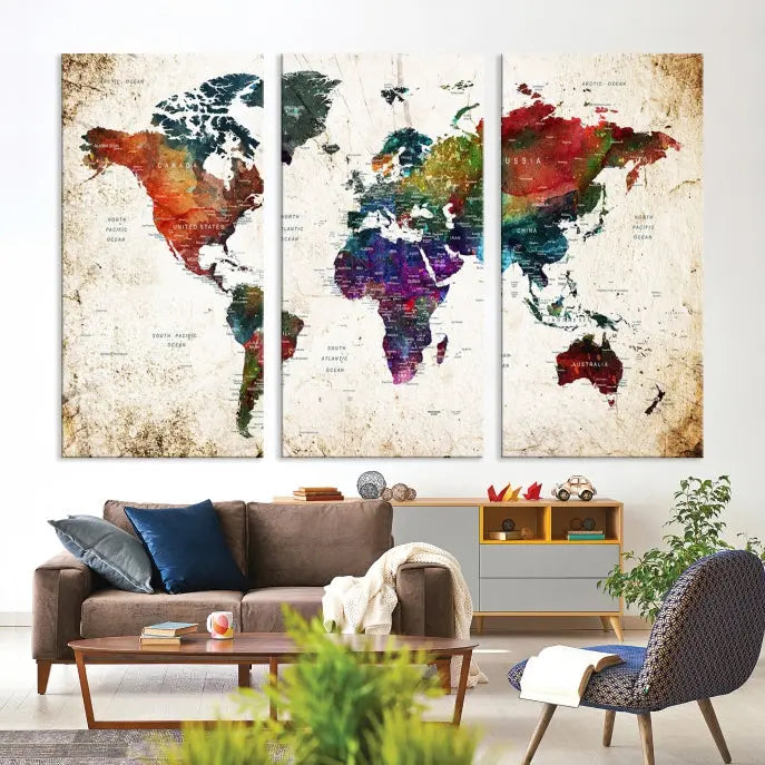 A three-panel Watercolor World Map Wall Art Canvas Print, crafted on museum-quality canvas with a UV-protective coating, is displayed against the dark wall. Ready to hang, it brings vibrant colors and sophistication to your space.