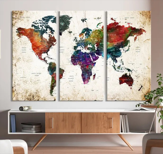 A three-panel Watercolor World Map Wall Art Canvas Print, crafted on museum-quality canvas with a UV-protective coating, is displayed against the dark wall. Ready to hang, it brings vibrant colors and sophistication to your space.