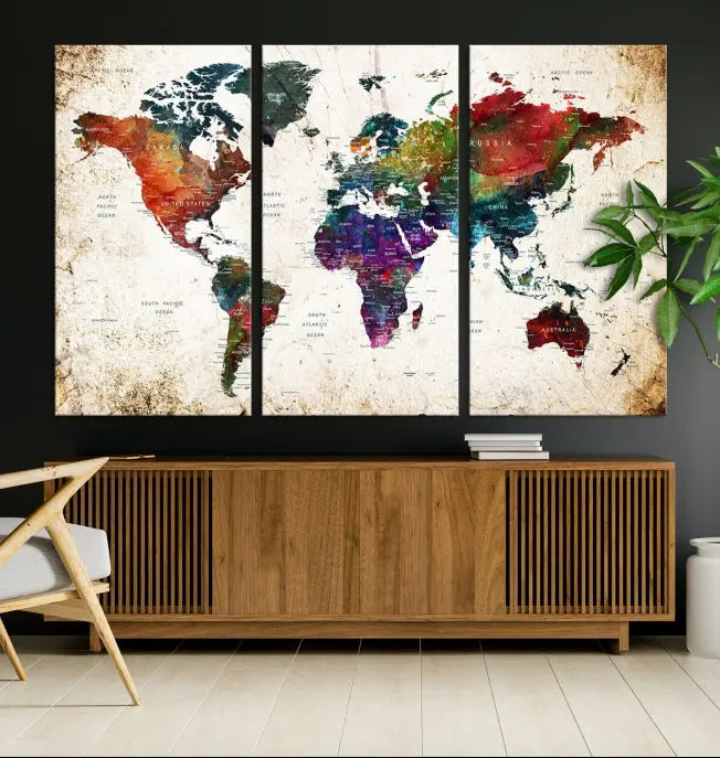 A three-panel Watercolor World Map Wall Art Canvas Print, crafted on museum-quality canvas with a UV-protective coating, is displayed against the dark wall. Ready to hang, it brings vibrant colors and sophistication to your space.