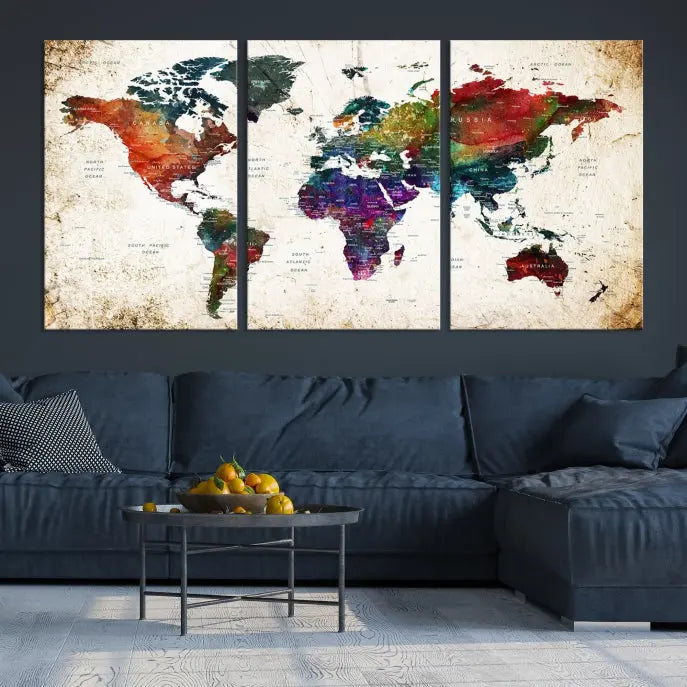 A three-panel Watercolor World Map Wall Art Canvas Print, crafted on museum-quality canvas with a UV-protective coating, is displayed against the dark wall. Ready to hang, it brings vibrant colors and sophistication to your space.