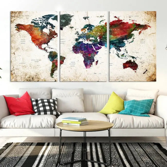 A three-panel Watercolor World Map Wall Art Canvas Print, crafted on museum-quality canvas with a UV-protective coating, is displayed against the dark wall. Ready to hang, it brings vibrant colors and sophistication to your space.