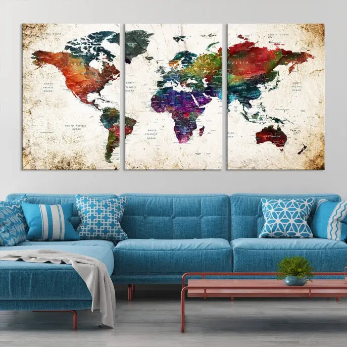 A three-panel Watercolor World Map Wall Art Canvas Print, crafted on museum-quality canvas with a UV-protective coating, is displayed against the dark wall. Ready to hang, it brings vibrant colors and sophistication to your space.