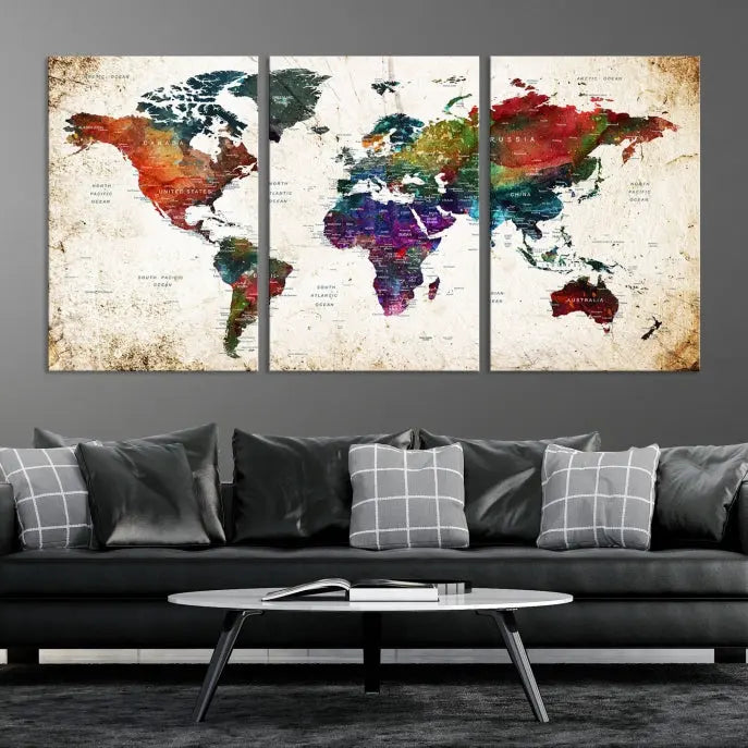 A three-panel Watercolor World Map Wall Art Canvas Print, crafted on museum-quality canvas with a UV-protective coating, is displayed against the dark wall. Ready to hang, it brings vibrant colors and sophistication to your space.