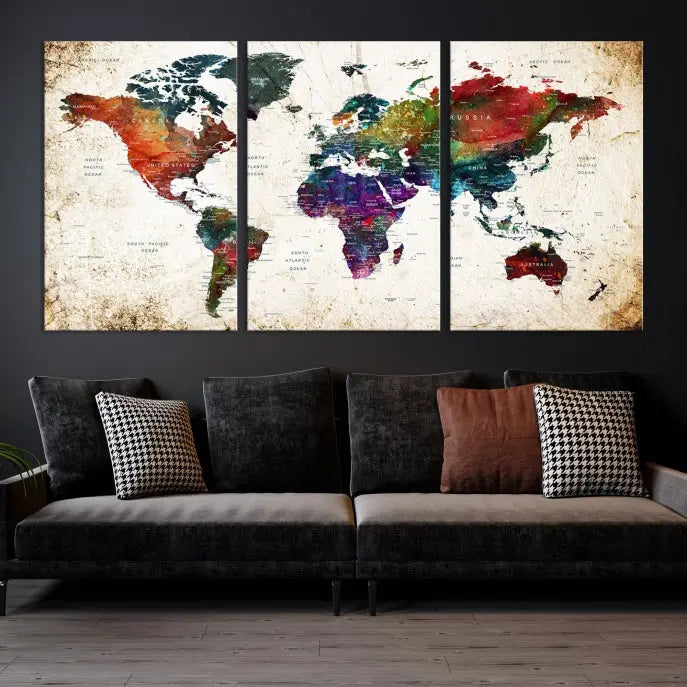 A three-panel Watercolor World Map Wall Art Canvas Print, crafted on museum-quality canvas with a UV-protective coating, is displayed against the dark wall. Ready to hang, it brings vibrant colors and sophistication to your space.