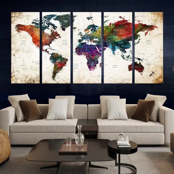 A three-panel Watercolor World Map Wall Art Canvas Print, crafted on museum-quality canvas with a UV-protective coating, is displayed against the dark wall. Ready to hang, it brings vibrant colors and sophistication to your space.