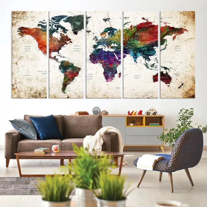 A three-panel Watercolor World Map Wall Art Canvas Print, crafted on museum-quality canvas with a UV-protective coating, is displayed against the dark wall. Ready to hang, it brings vibrant colors and sophistication to your space.