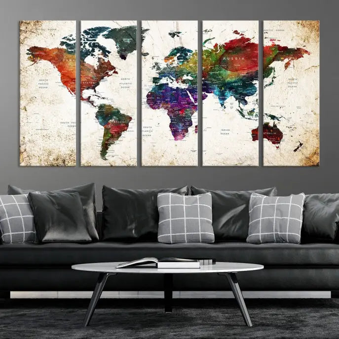 A three-panel Watercolor World Map Wall Art Canvas Print, crafted on museum-quality canvas with a UV-protective coating, is displayed against the dark wall. Ready to hang, it brings vibrant colors and sophistication to your space.