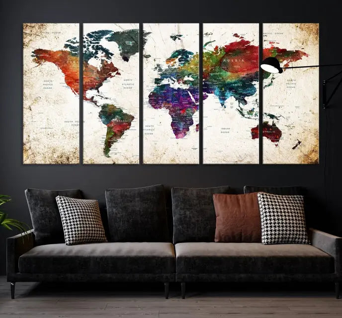 A three-panel Watercolor World Map Wall Art Canvas Print, crafted on museum-quality canvas with a UV-protective coating, is displayed against the dark wall. Ready to hang, it brings vibrant colors and sophistication to your space.