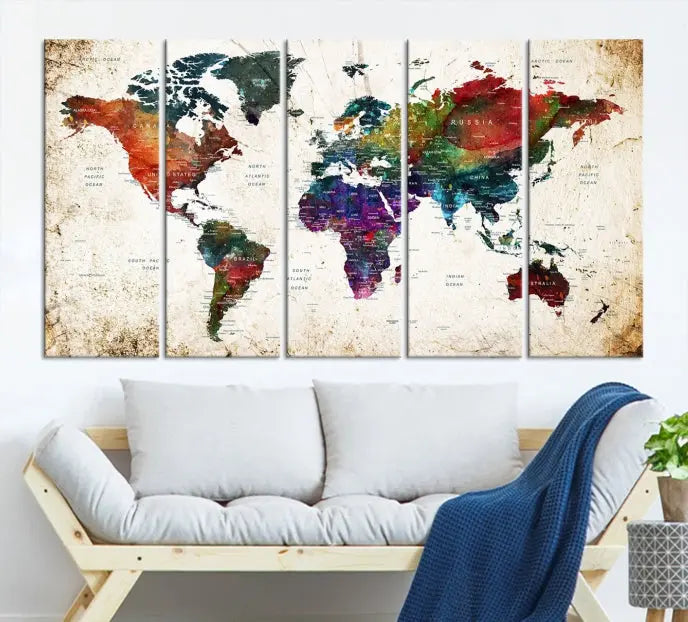 A three-panel Watercolor World Map Wall Art Canvas Print, crafted on museum-quality canvas with a UV-protective coating, is displayed against the dark wall. Ready to hang, it brings vibrant colors and sophistication to your space.