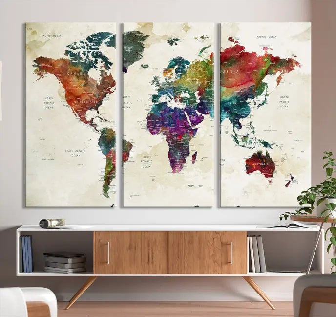 The room showcases the Watercolor World Map Wall Art Canvas Print, professionally framed on museum-quality pollycotton canvas.