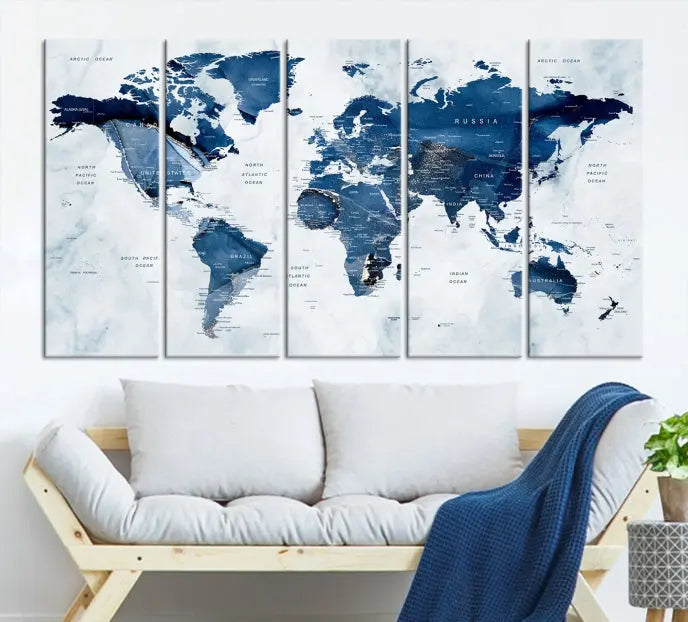 A beautifully gallery-wrapped Watercolor World Map Wall Art Canvas Print in dark blue hues hangs on the wall.