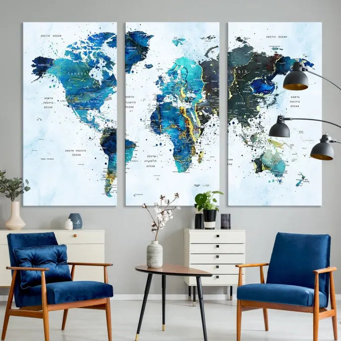 A Watercolor World Map Wall Art Canvas Print, arranged as a gallery-wrapped triptych in soothing blue and green tones, is displayed prominently.