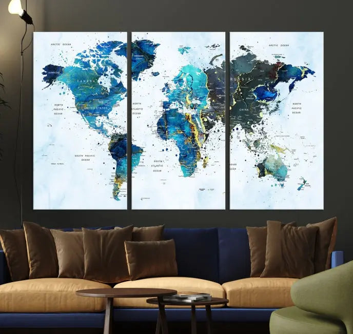 A Watercolor World Map Wall Art Canvas Print, arranged as a gallery-wrapped triptych in soothing blue and green tones, is displayed prominently.