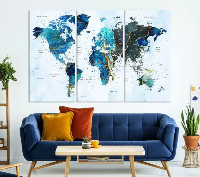 A Watercolor World Map Wall Art Canvas Print, arranged as a gallery-wrapped triptych in soothing blue and green tones, is displayed prominently.