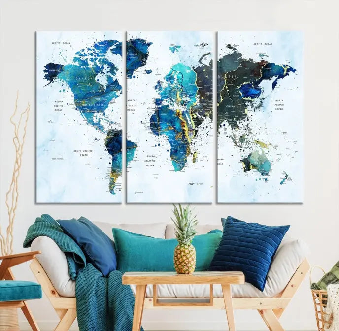 A Watercolor World Map Wall Art Canvas Print, arranged as a gallery-wrapped triptych in soothing blue and green tones, is displayed prominently.