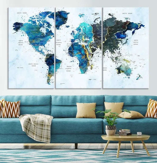 A Watercolor World Map Wall Art Canvas Print, arranged as a gallery-wrapped triptych in soothing blue and green tones, is displayed prominently.